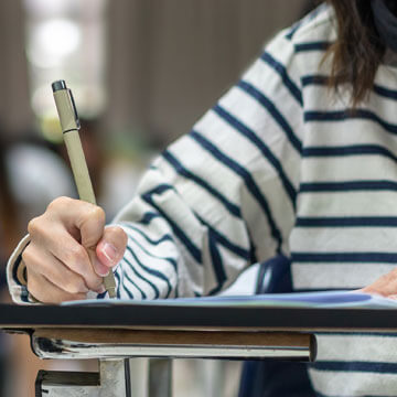 Student completing homework at desk at school